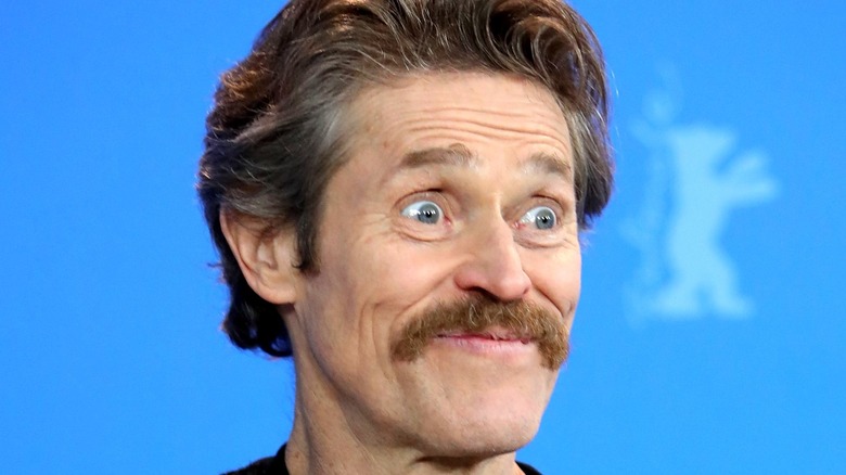 Willem Dafoe wide-eyed smile