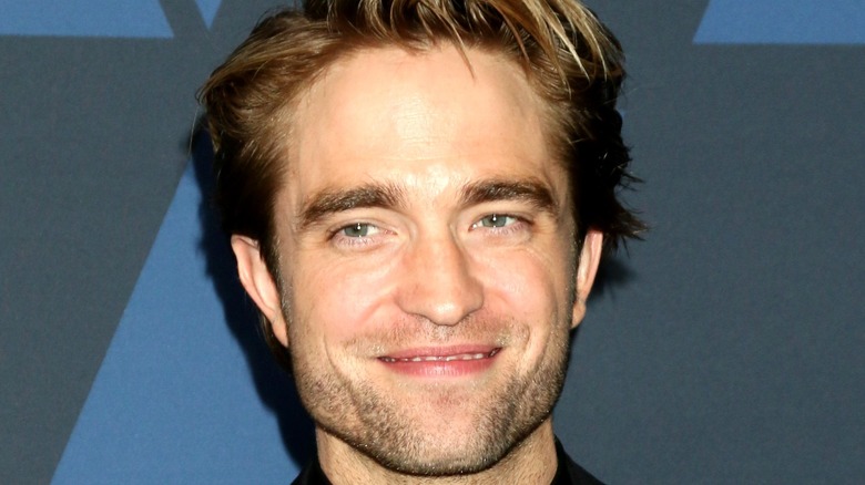 Robert Pattinson smiling for a press photo