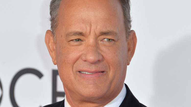 Tom Hanks smiles slightly