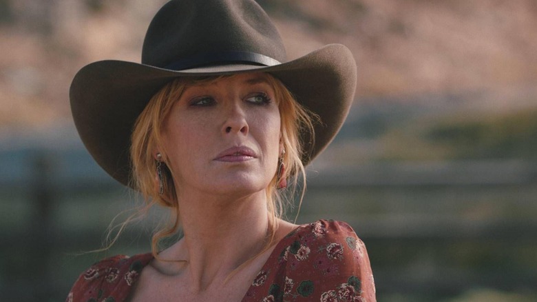 Beth in a cowboy hat looks into the distance in Yellowstone