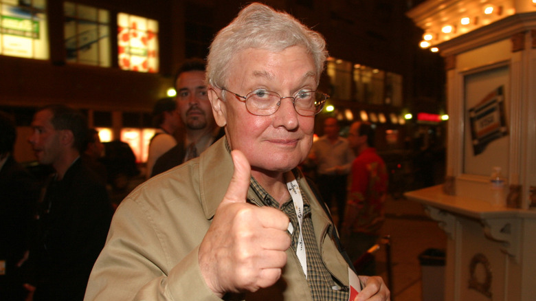 Roger Ebert smiling and giving a thumb's up on the red carpet in 2004