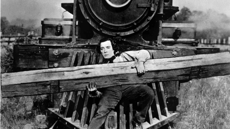 Johnny Gray riding a Locomotive while carrying a railroad tie in "The General"