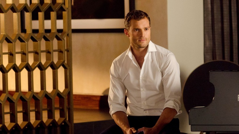 Christian Grey sitting at piano