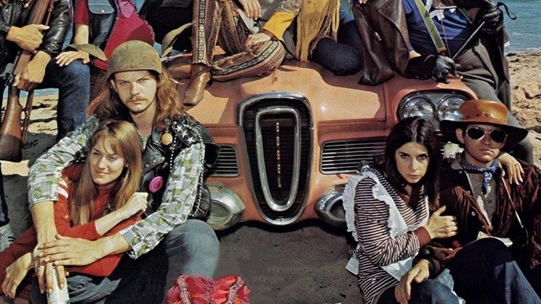 Friends sitting in front of a car