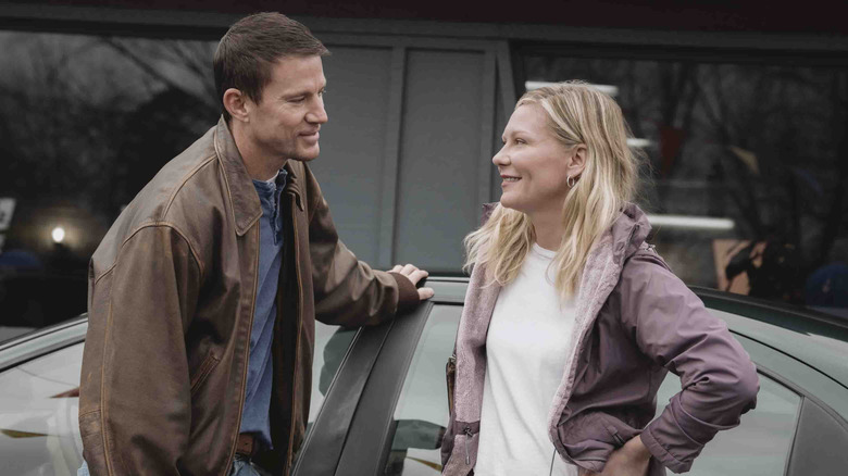 Jeff and Leigh stand by a car in "Roofman" (2025)