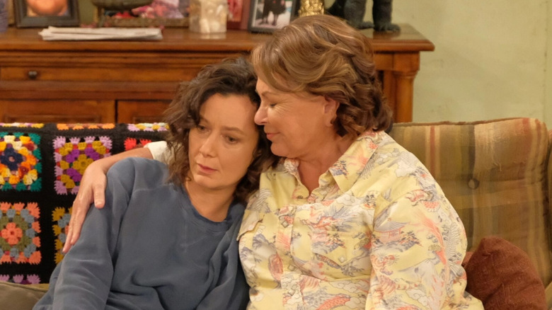Roseanne and Darlene Connor hug on the couch in "Roseanne"