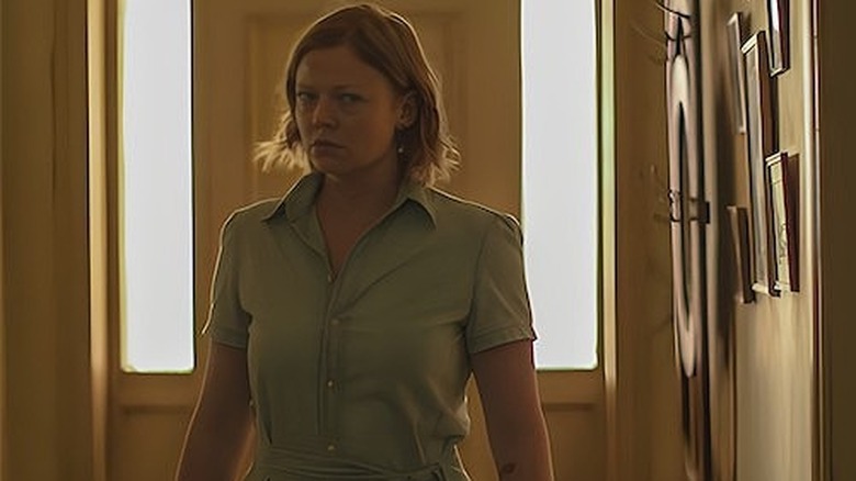 Sarah looking suspiciously down a hallway