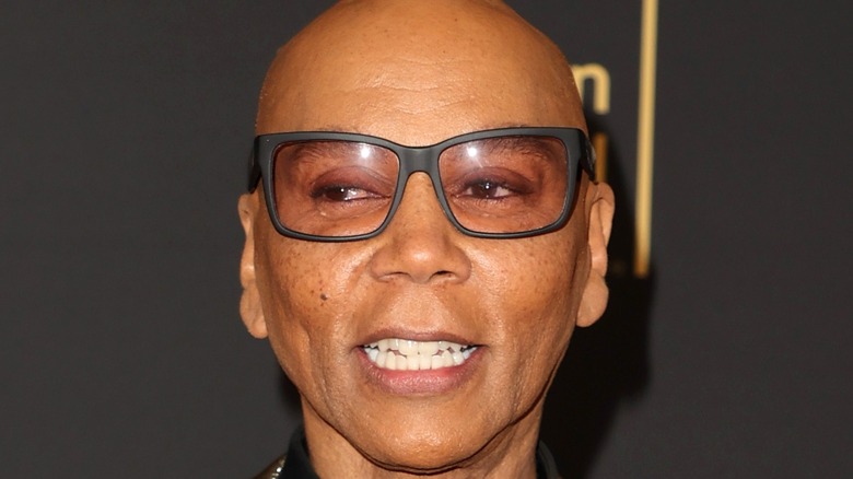 RuPaul with glasses smiles at event