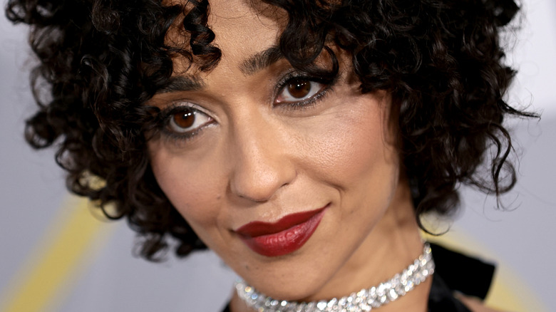 Ruth Negga wearing a shiny necklace and red lipstick