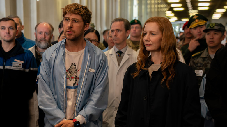 Ryland and Eva standing together at front of crowd in Project Hail Mary