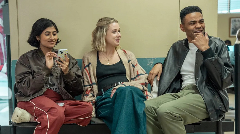 Issa Billie and Anton sitting on a bench laughing in Adults