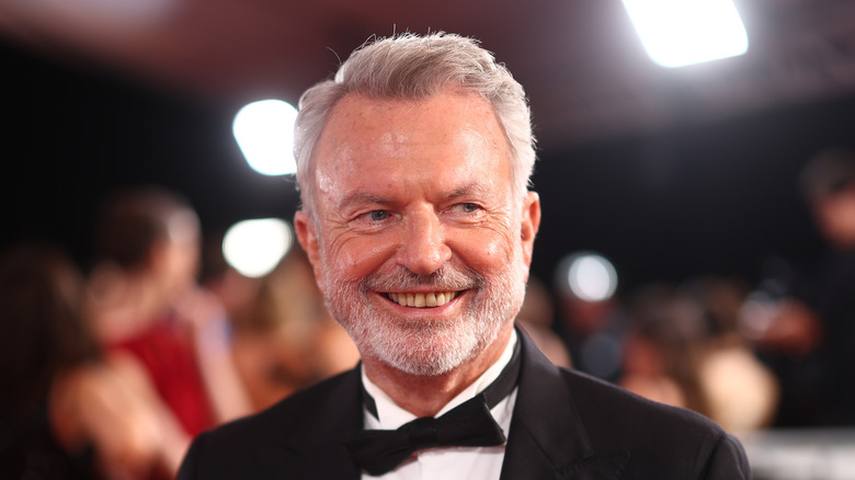Sam Neill smiling while wearing a tuxedo