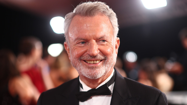 Sam Neill smiling while wearing a tuxedo