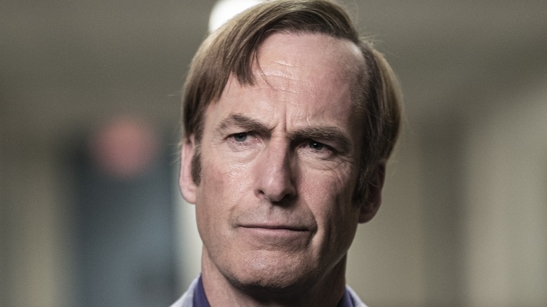 Bob Odenkirk smiles holding a trophy 