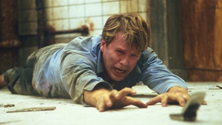 Dr. Gordon reaches for the phone in "Saw" (2004)