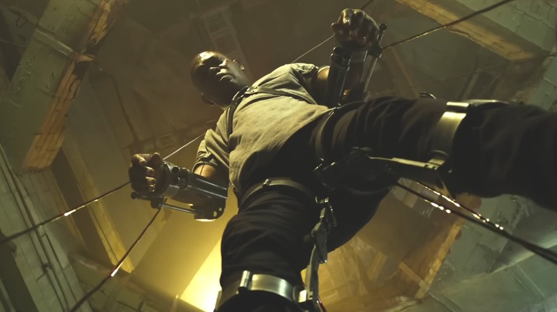 Marcus Banks being held up in a wire trap in "Spiral: From the Book of Saw" (2021)