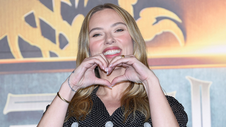 Scarlett Johansson smiling and forming a heart with her hands