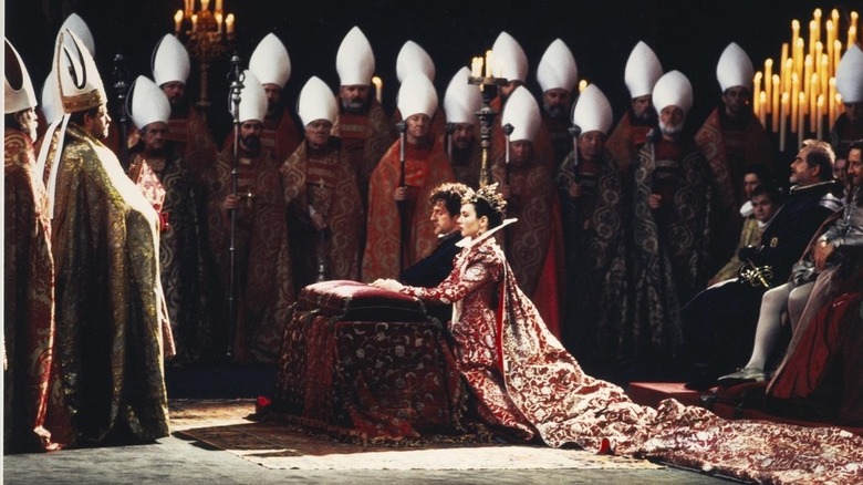 Margot and Henry sit surrounded by clergy in "Le Reine Margot" (1994)