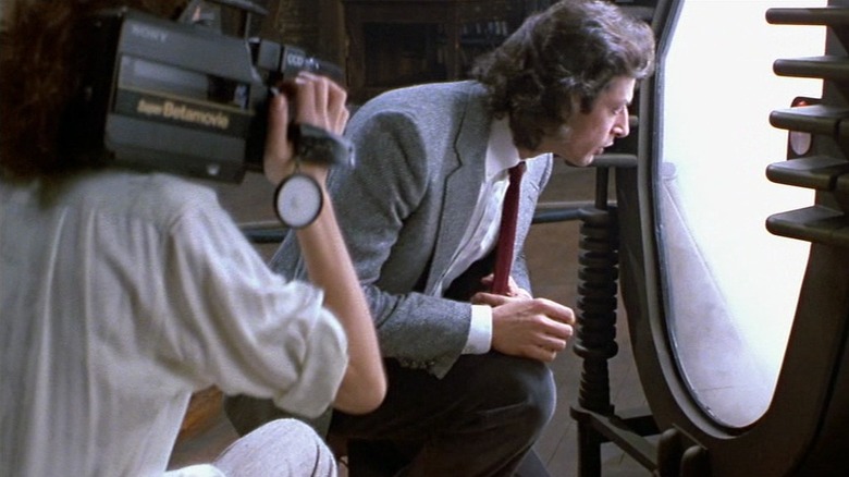 Seth Brundle looking into his machine in "The Fly" (1986)