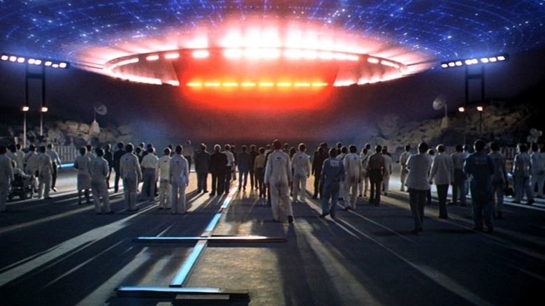 A group of humans gathered around a landing spaceship in "Close Encounters of the Third Kind"