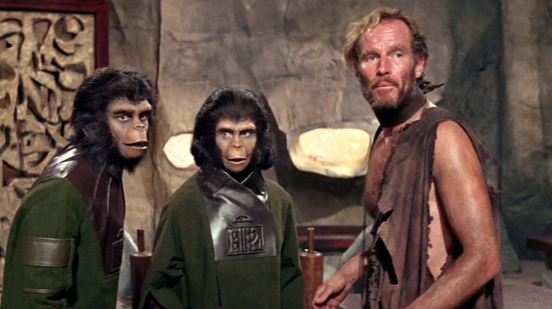 A man and two apes standing together in "Planet of the Apes"