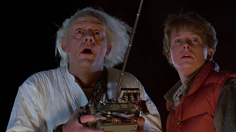 Doc Brown holding a controller next to Marty in Back to the Future (1985)