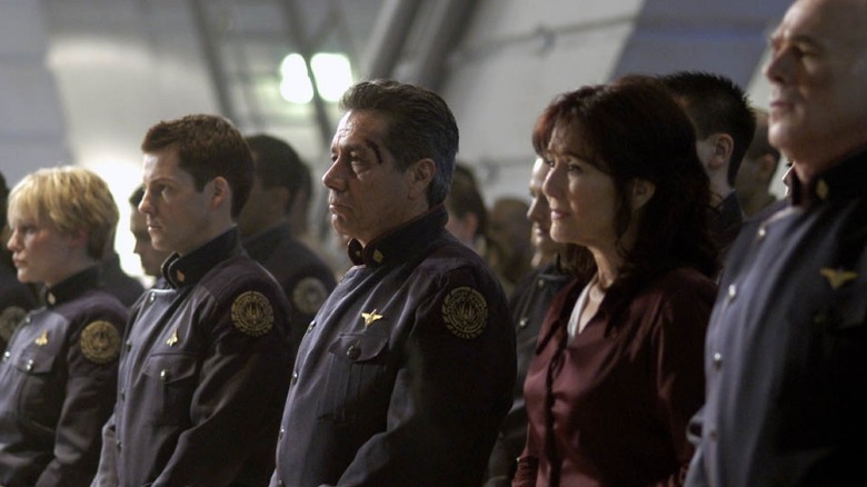 Adama, Apollo, Starbuck, and others standing at attention in Battlestar Galactica (2004)
