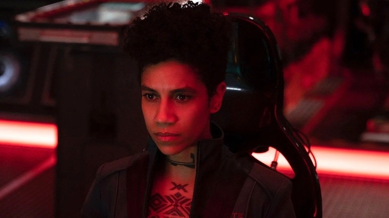 Naomi Nagata sitting in red light in The Expanse
