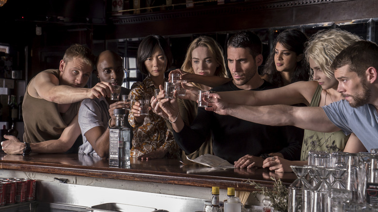 All eight members of the cluster making a toast at a bar in Sense8