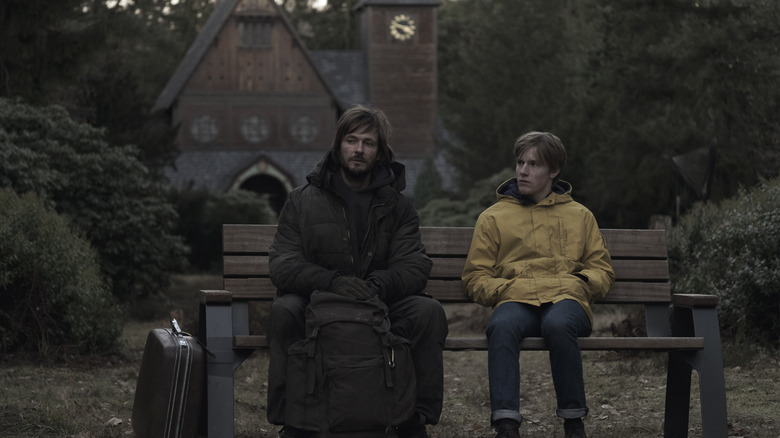 Adult Jonas and teenage Jonas sitting on a bench in "Dark" (2017)