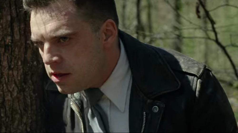 Sebastian Stan leaning against tree