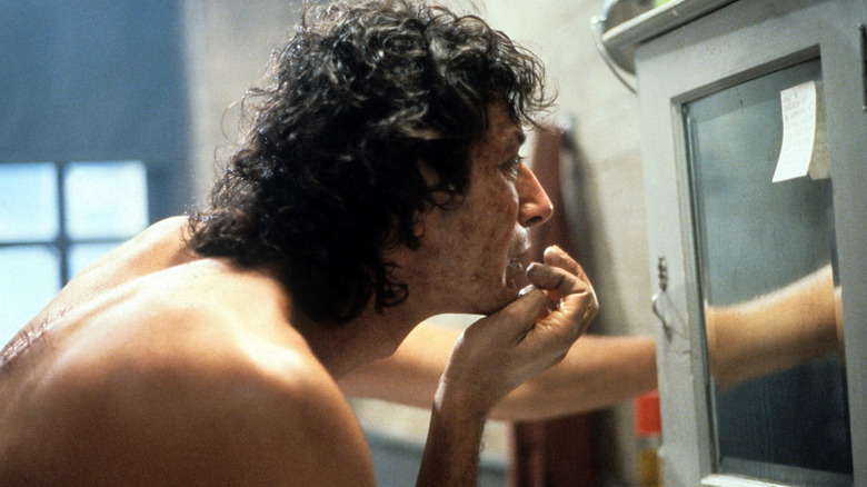 The Fly picking at his face