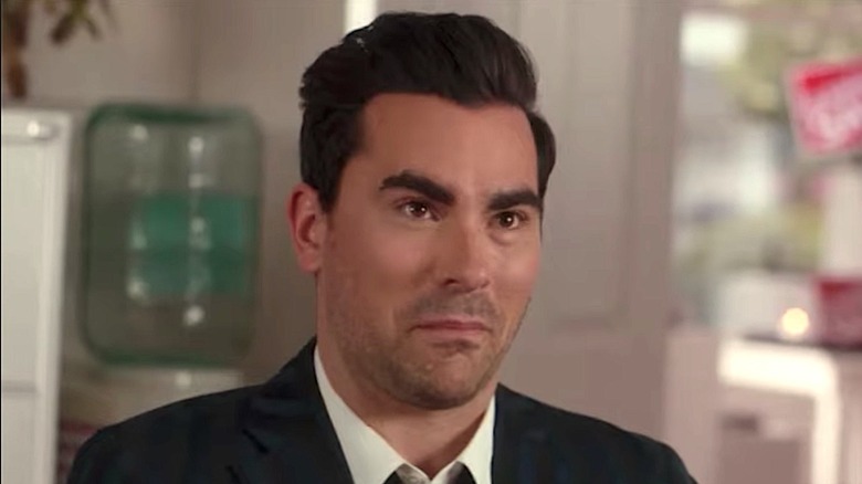 Dan Levy smirking