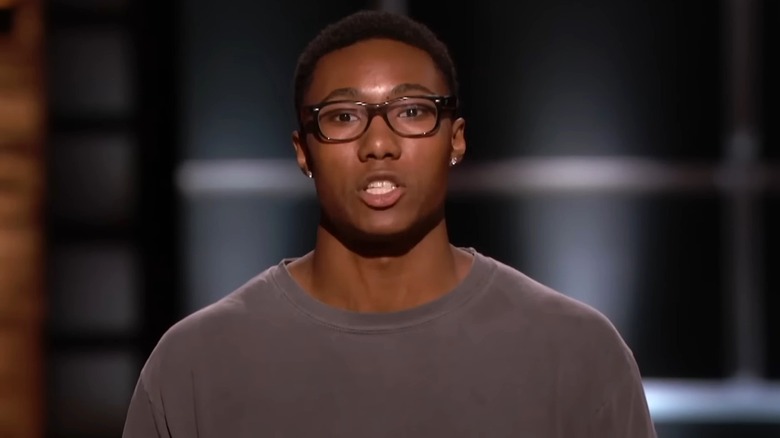 Ryan Diew wearing glasses and a brown shirt while appearing on Shark Tank