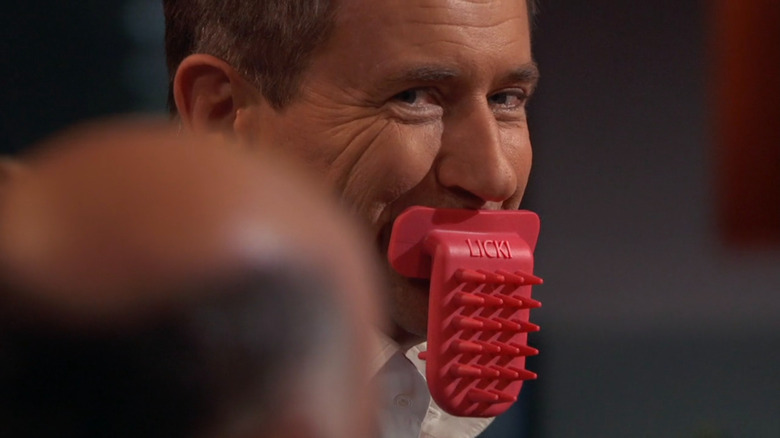 Robert Herjavec with a LICKI Brush in his mouth on Shark Tank