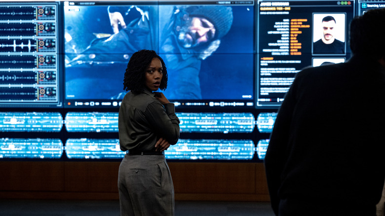 Roberta Frost turning around in front of big screen monitors