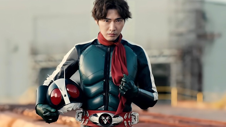 Kamen Rider holding helmet wearing armor