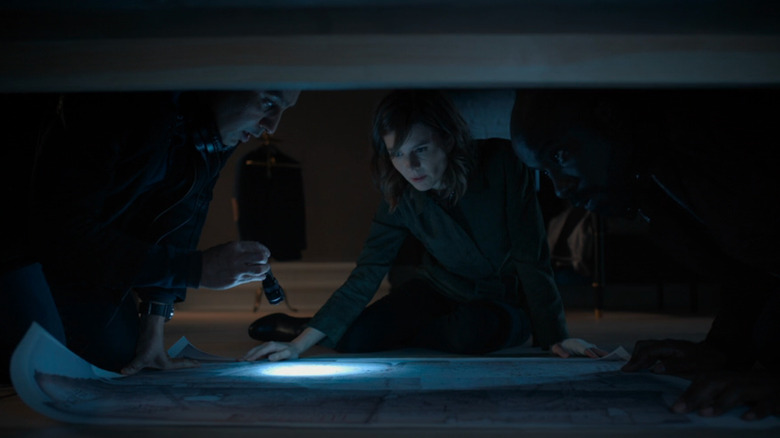 The Evil team examines a document