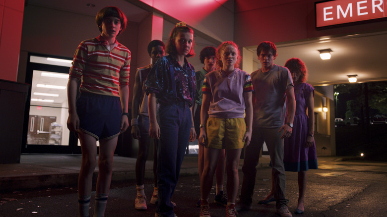 The kids of Stranger Things look nervously at something