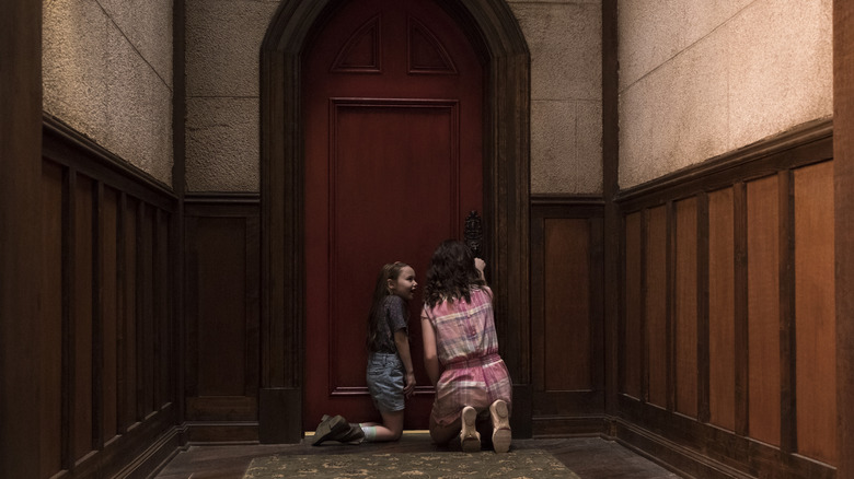 Two of the young Crain children at a locked door in The Haunting of Hill House