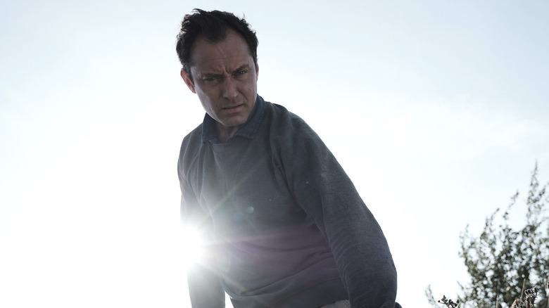 Jude Law looks at something puzzling in The Third Day