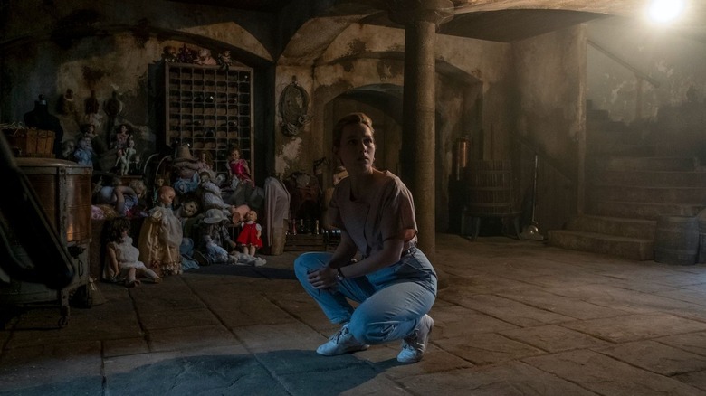 Dani Clayton crouches in basement