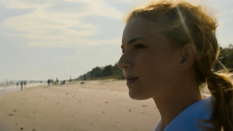 Emily stands on the shore looking at the sea