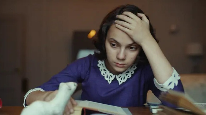 Lyra holds up the golden compass
