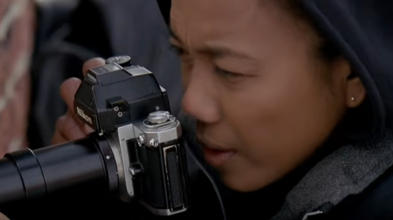 Kima Greggs looks through camera