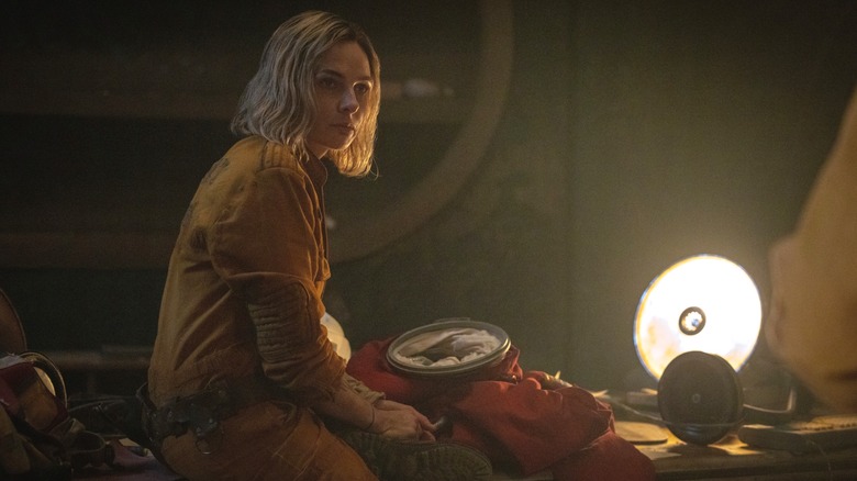 Juliette sitting in lamp light in "Silo."