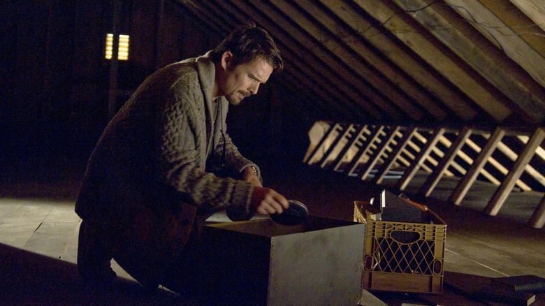 Ellison rummaging through a box of film reels in the attic