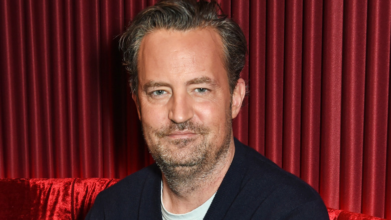 Matthew Perry on red chair