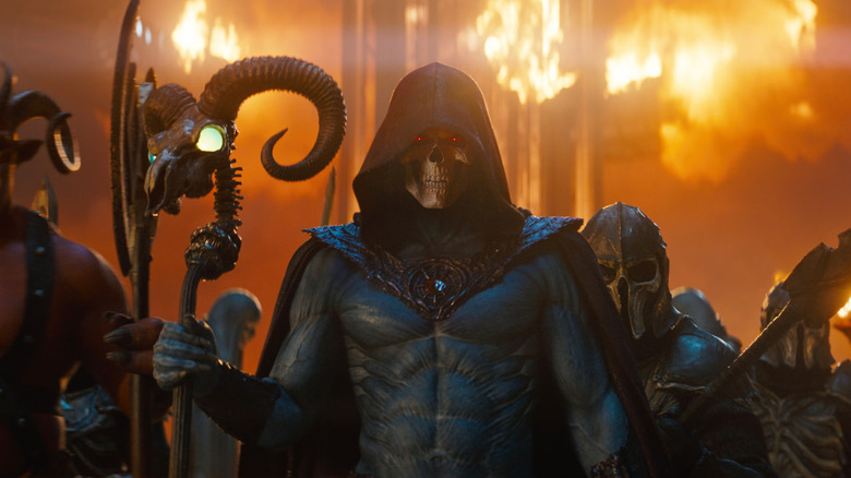 Skeletor holding his ram staff surrounded by flames and soldiers in 