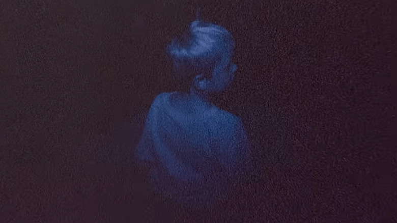 A child sitting alone in the dark in Skinamarink